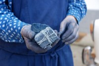 Les mains d’un teinturier-imprimeur autrichien tenant deux blocs de pigment indigo indien  © Catherine Legrand