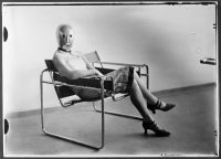  Erich Consemüller, Scène du Bauhaus : inconnue au masque dans un fauteuil tubulaire de Marcel Breuer portant un masque de Oskar Schlemmer et une robe de Lis Beyer. Photographie, 1926 © Bauhaus-Archiv Berlin